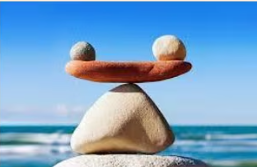 A stack of stones balanced on a beach, with the sea and sky behind